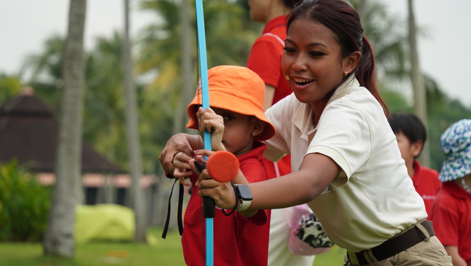 Smiling girl holding a fishing rod during an introductory fishing activity