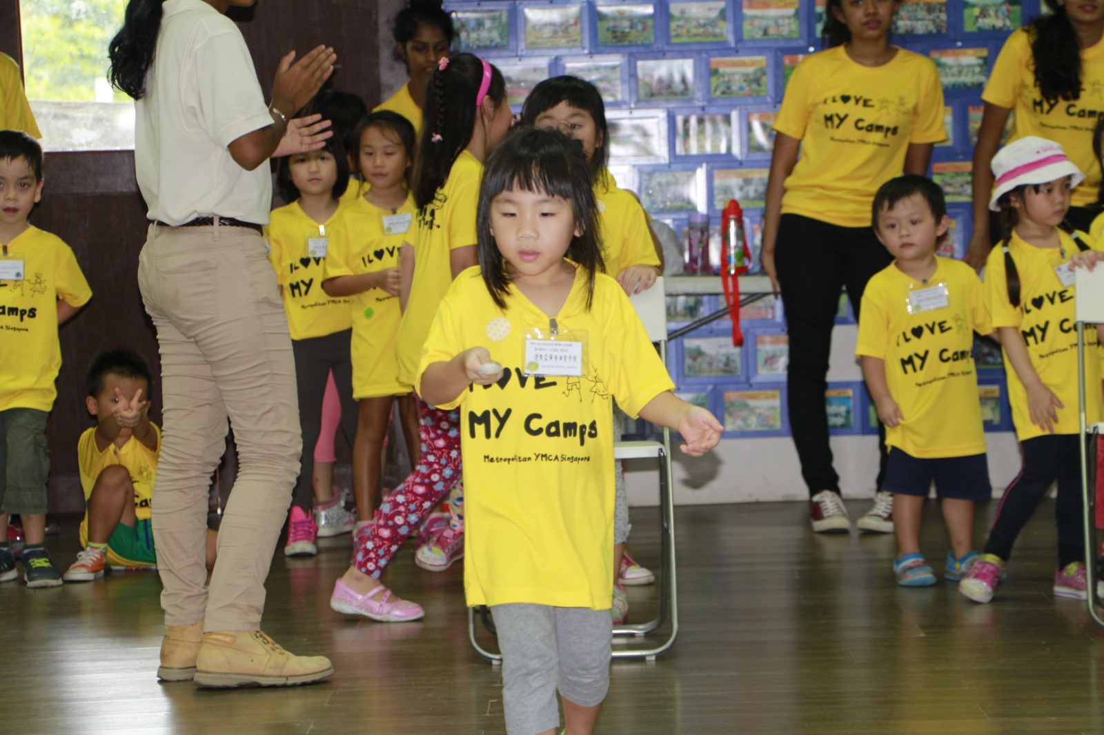 Young campers in yellow T-shirts playing an indoor ice-breaker game